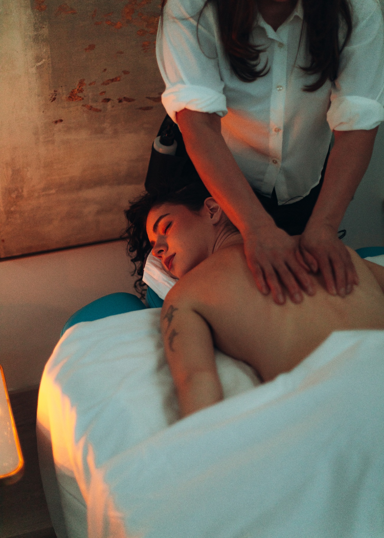 Guest receiving a relaxing back massage in a warmly lit treatment room